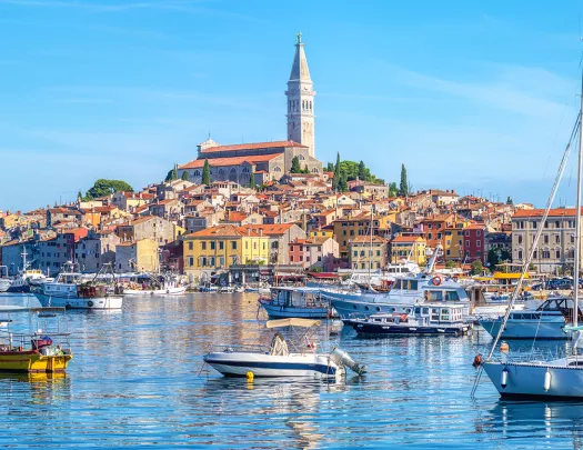 Ocean full of floating boats and a town on a small island