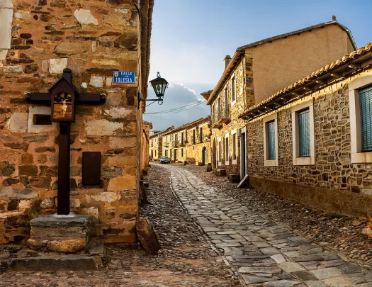 Alleyway shot of stone-built town, windows, doors dot the alley.