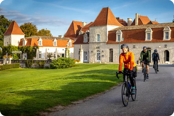 cyclists riding by a village