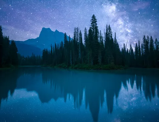 Lake, mountain, forest, vibrant nighttime vista.