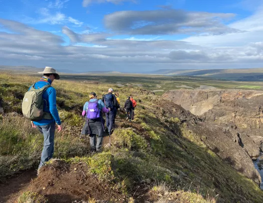 Hikers walk along a rocky mountain path