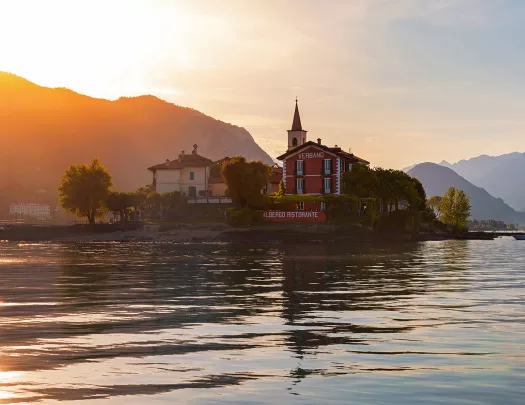 Wide shot of the Albergo Ristorante and it's surrounding lake, sunset.