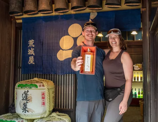 Two people pose outside a store