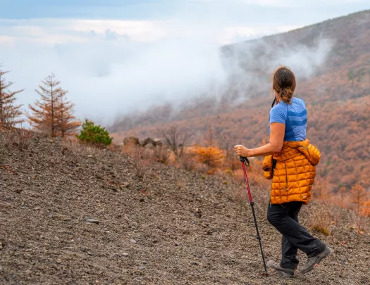 Woman ascending on a rocky, foggy hill