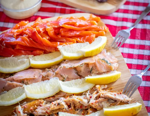 Wooden plank full of cured fish and lemon slices