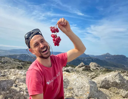 Leader with charcuterie platter, pretending to eat grapes.