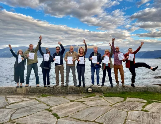 Group of hikers holding up a sign that spells our Backroads