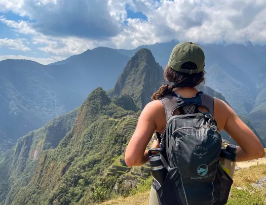 Guest overlooking Machu Picchu from high cliff.