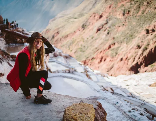 Backroads guest crouching in snow on hiking trail in Peru.