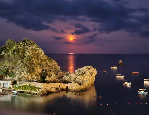 sun setting over an island