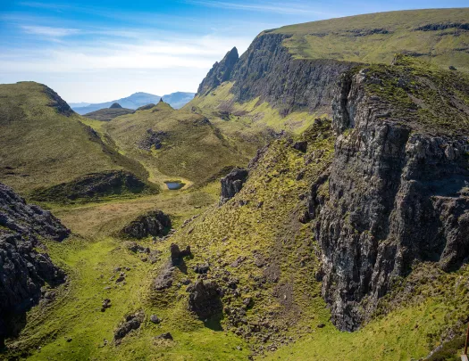 Open valley of grass with surrounding hills and cliffs