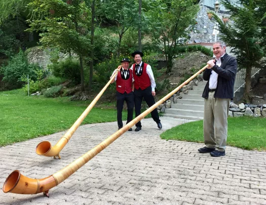 Two locals and guest playing Swiss horns.