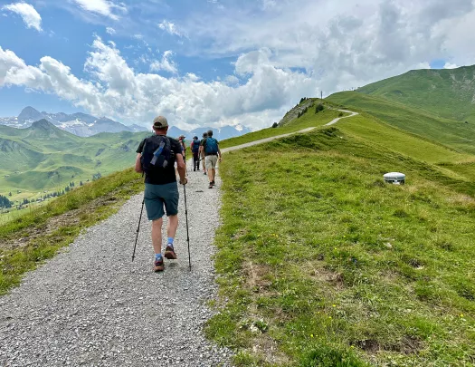 Group of people ascending a rocky trail on a mountain