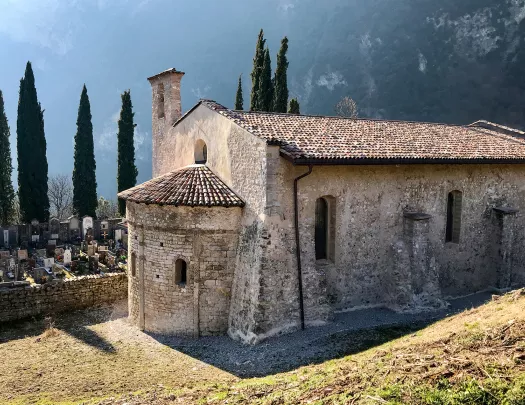 Shot of mountain cemetery building, gravestones in background.