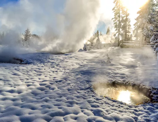 Snow covered landscape and hot springs with steam